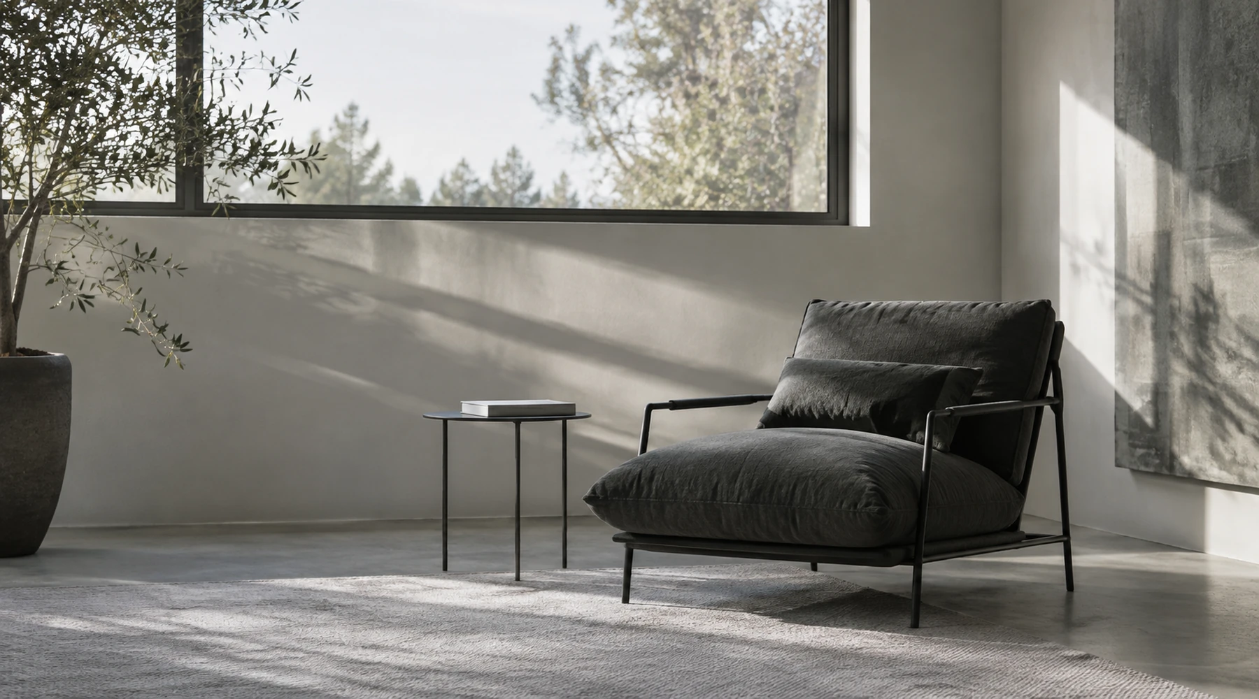 Angolo domestico con poltrona, tavolino e libro accanto a una finestra alta. / A home corner with an armchair, side table and book beside a tall window.